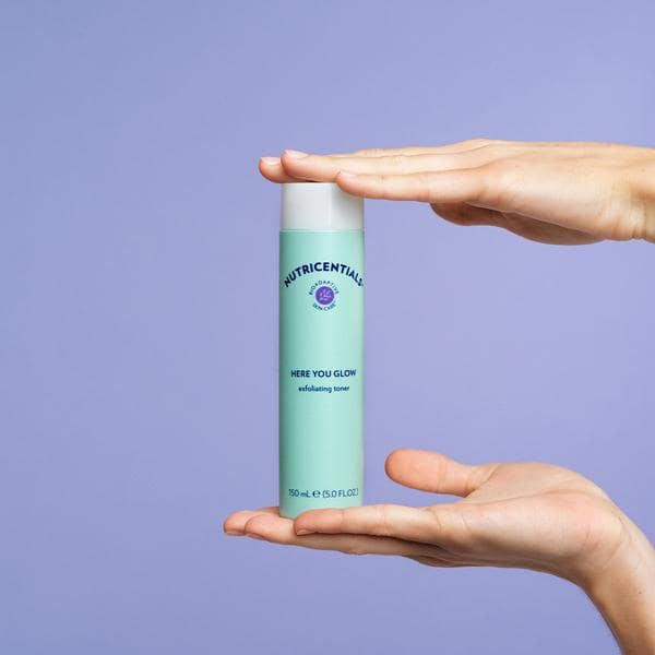 nu-skin-nutricentials-here-you-glow-exfoliating-toner-product-in-hands-lifestyle-image-min